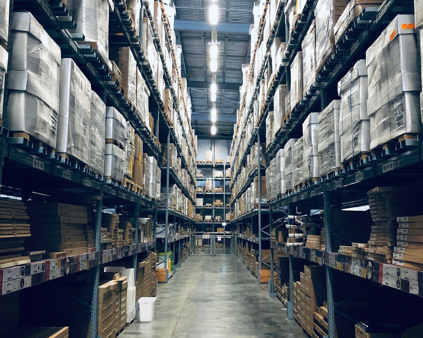 Long warehouse aisle lined with pallet racks and inventory