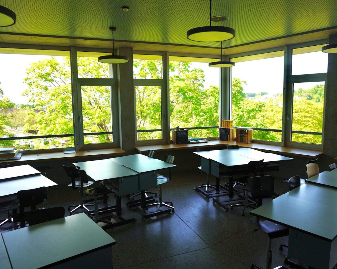 Empty modern classroom with study tables and large windows